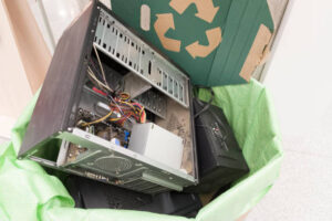 E-waste, electronics waste for reuse and recycle concept. Recycling bin full of old electronic devices in office building.
